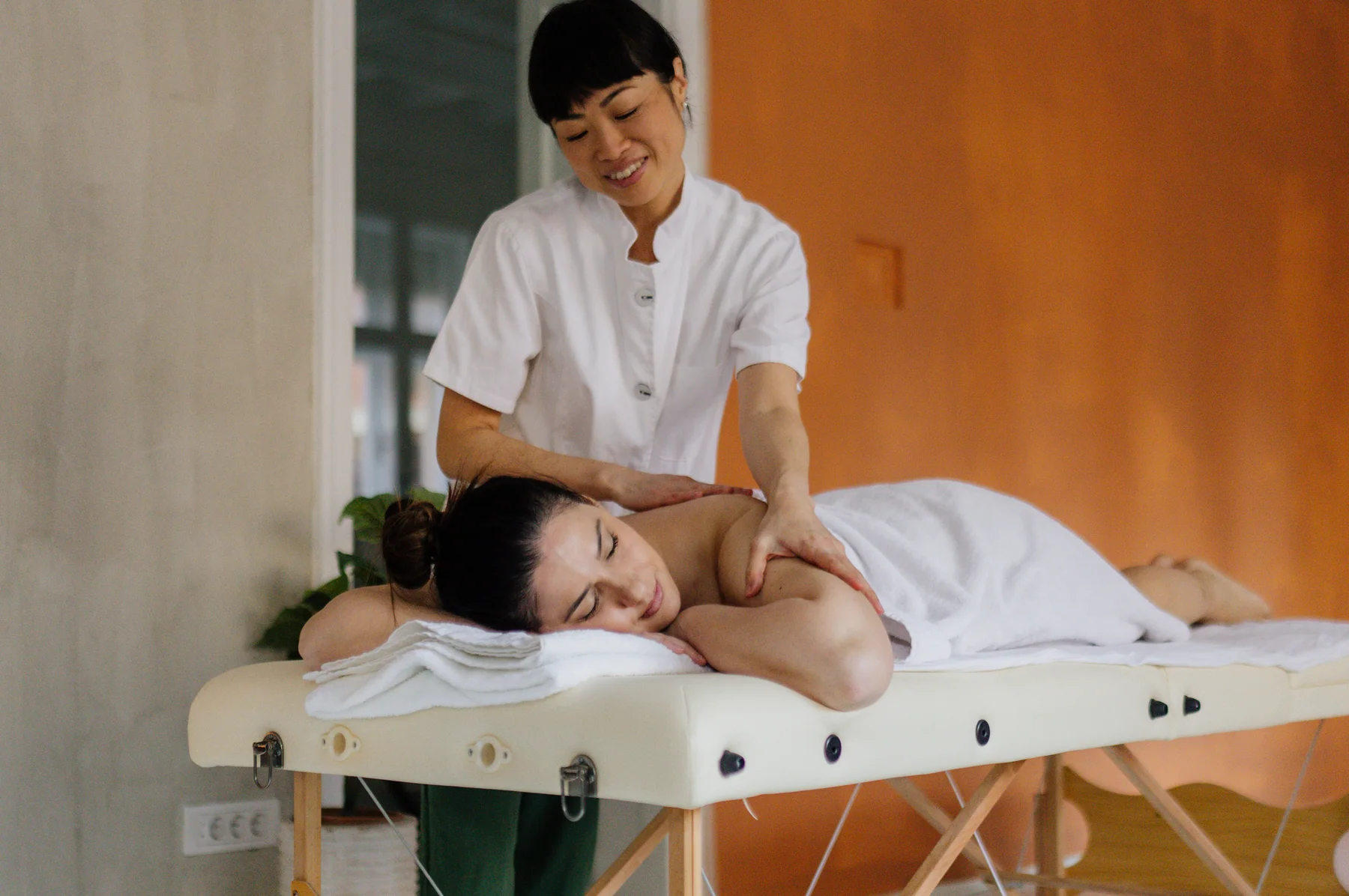 ベッドでボディ施術を受けているお客様