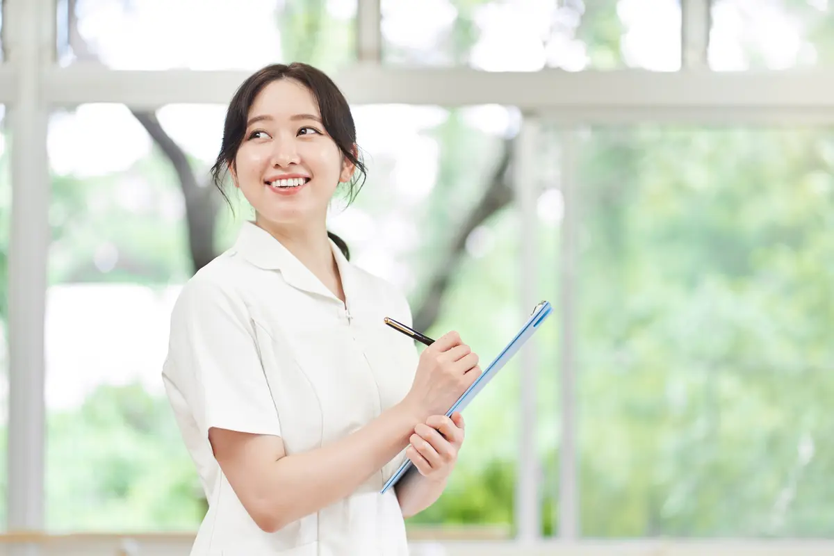 白衣でクリップボードを持つ看護師