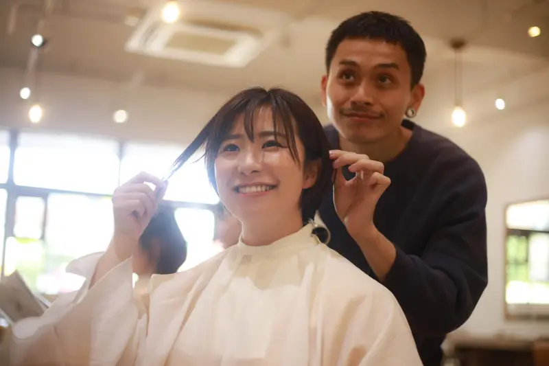 お客様と話しながら手を動かす美容師