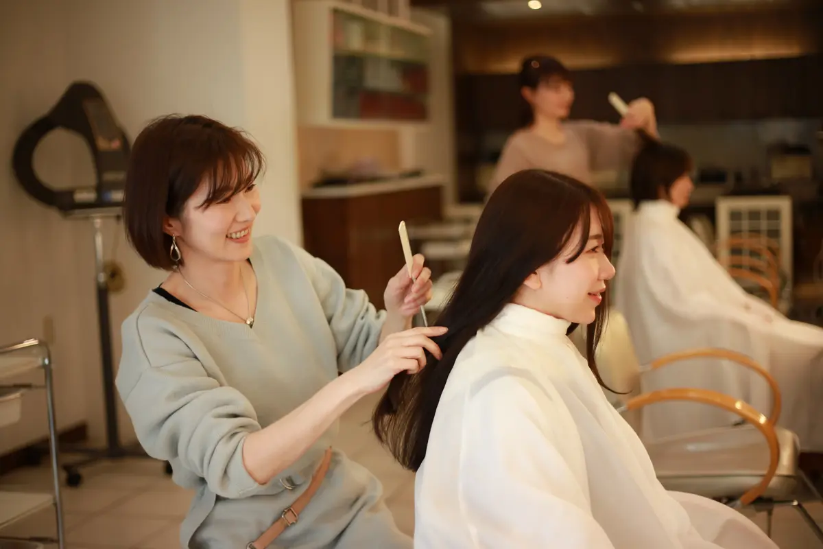 ロングヘアの毛先を整える美容師