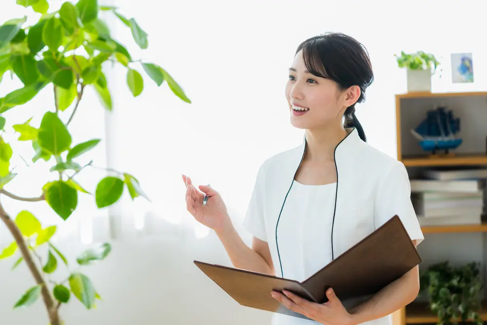 バインダーを手に説明するスタッフ