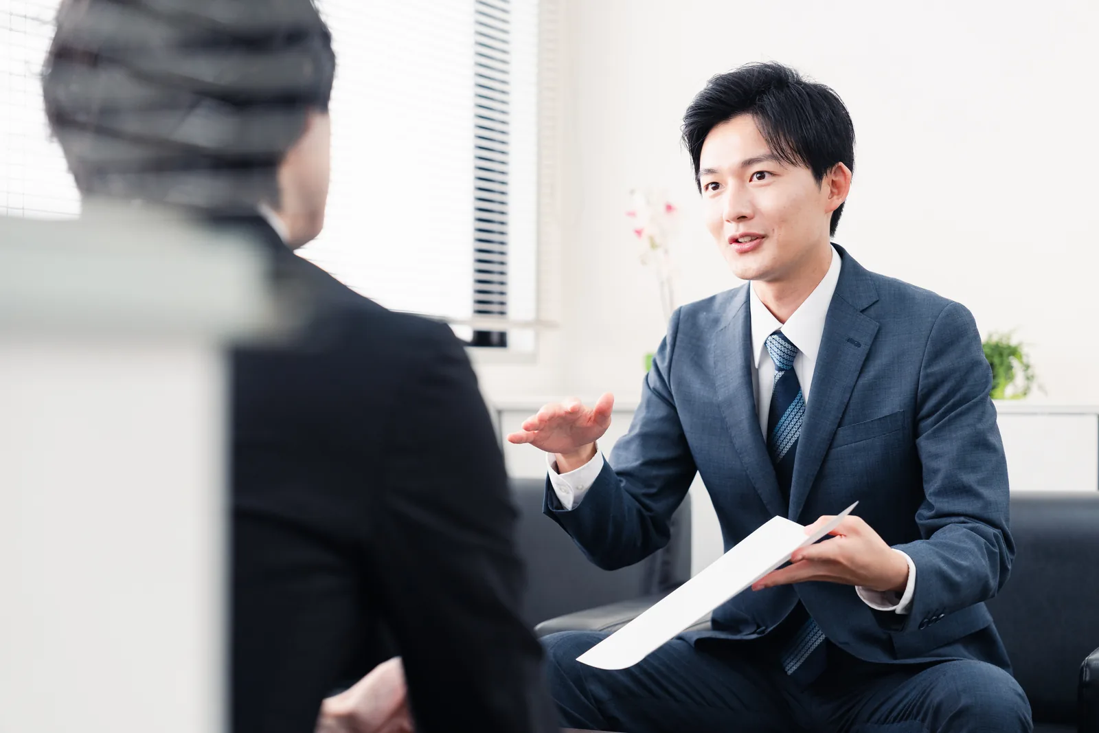 書類を提示して説明する営業担当