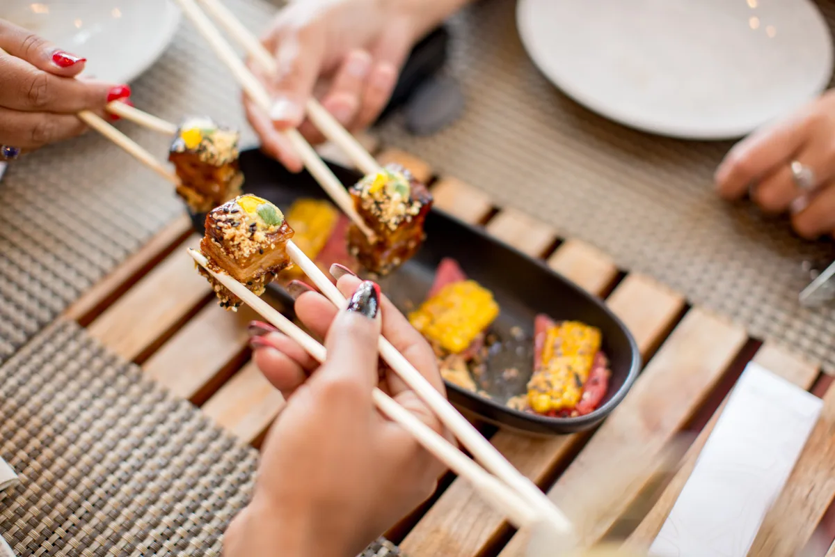 箸で料理を取る食事風景